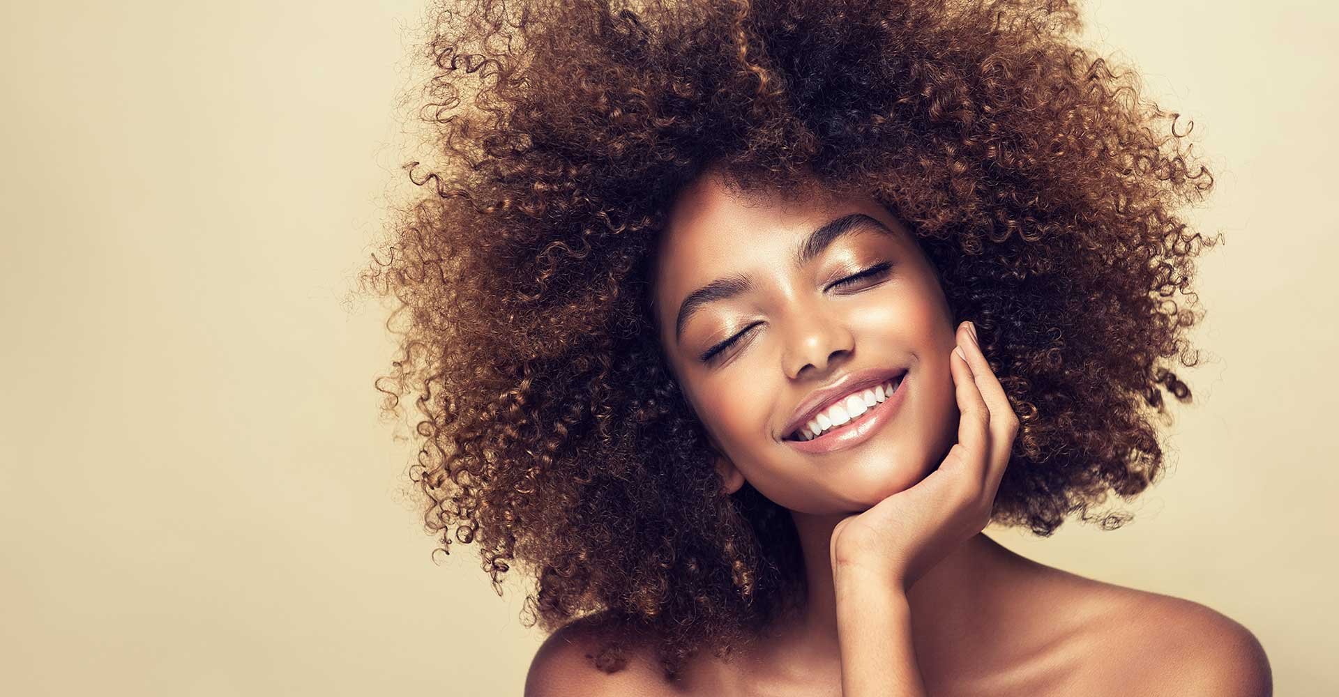 Modelo morena com cabelos cacheados e volumosos